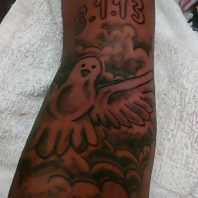Dove with clouds and date lettering tattoo on the forearm by Visionary Ink