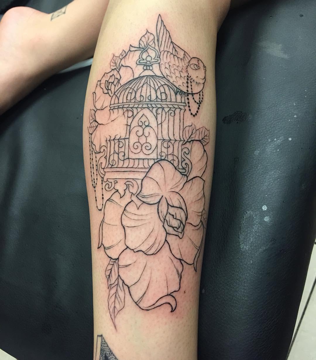 Birdcage with flowers and bird ornamental tattoo on the forearm by Chris