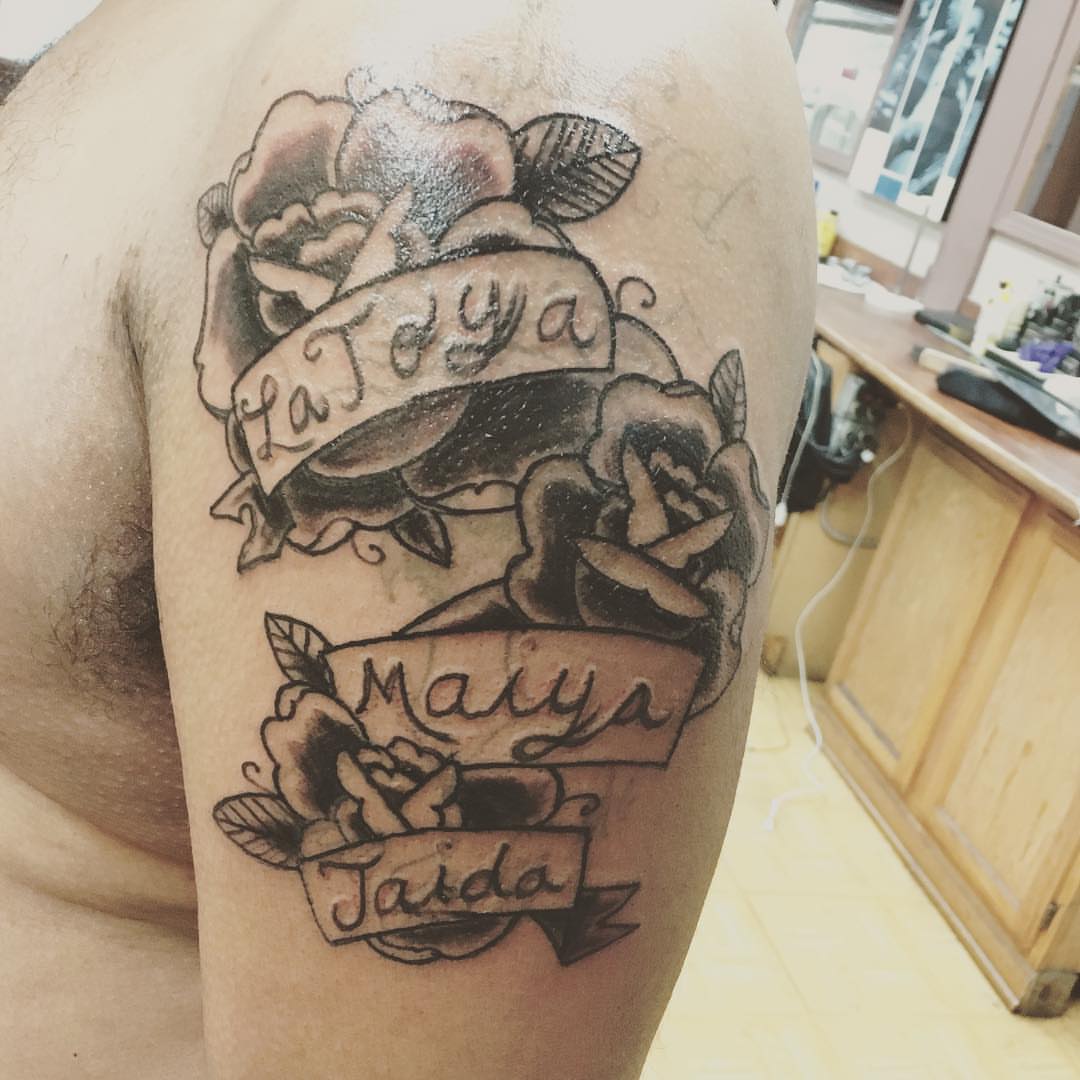 Names and roses American traditional tattoo on the thigh by Rashaun Collins