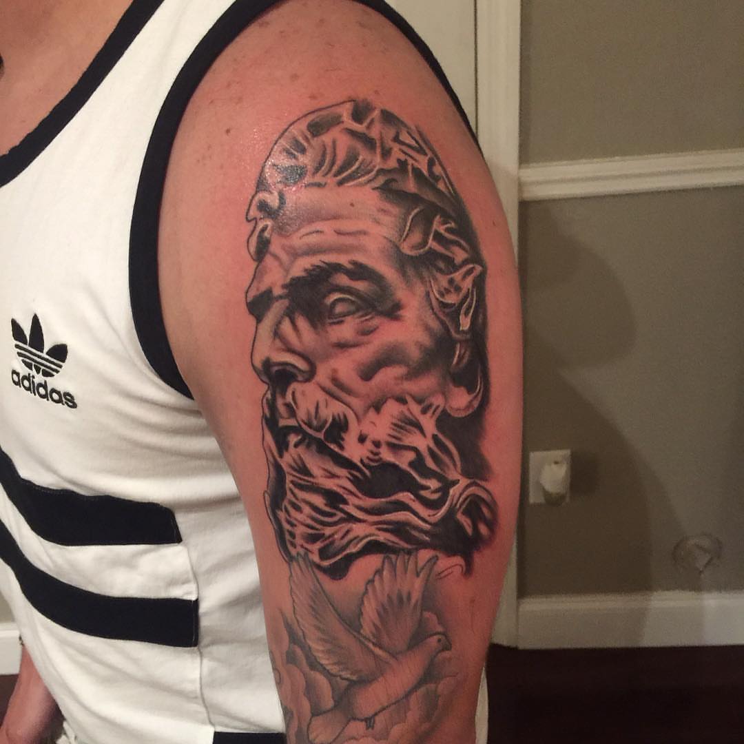 Man's face realism tattoo on the upper arm by Tattoos By Mauze