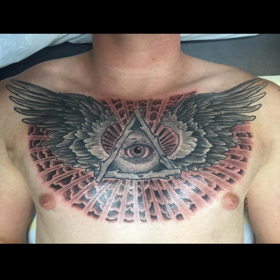 Eye and triangle geometric tattoo on the chest by Jason L.