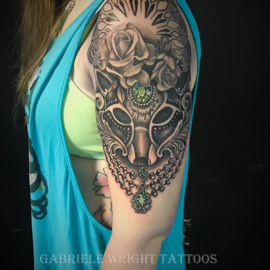 Mask with roses ornamental tattoo on the upper arm by GABRIELExTATTOOS