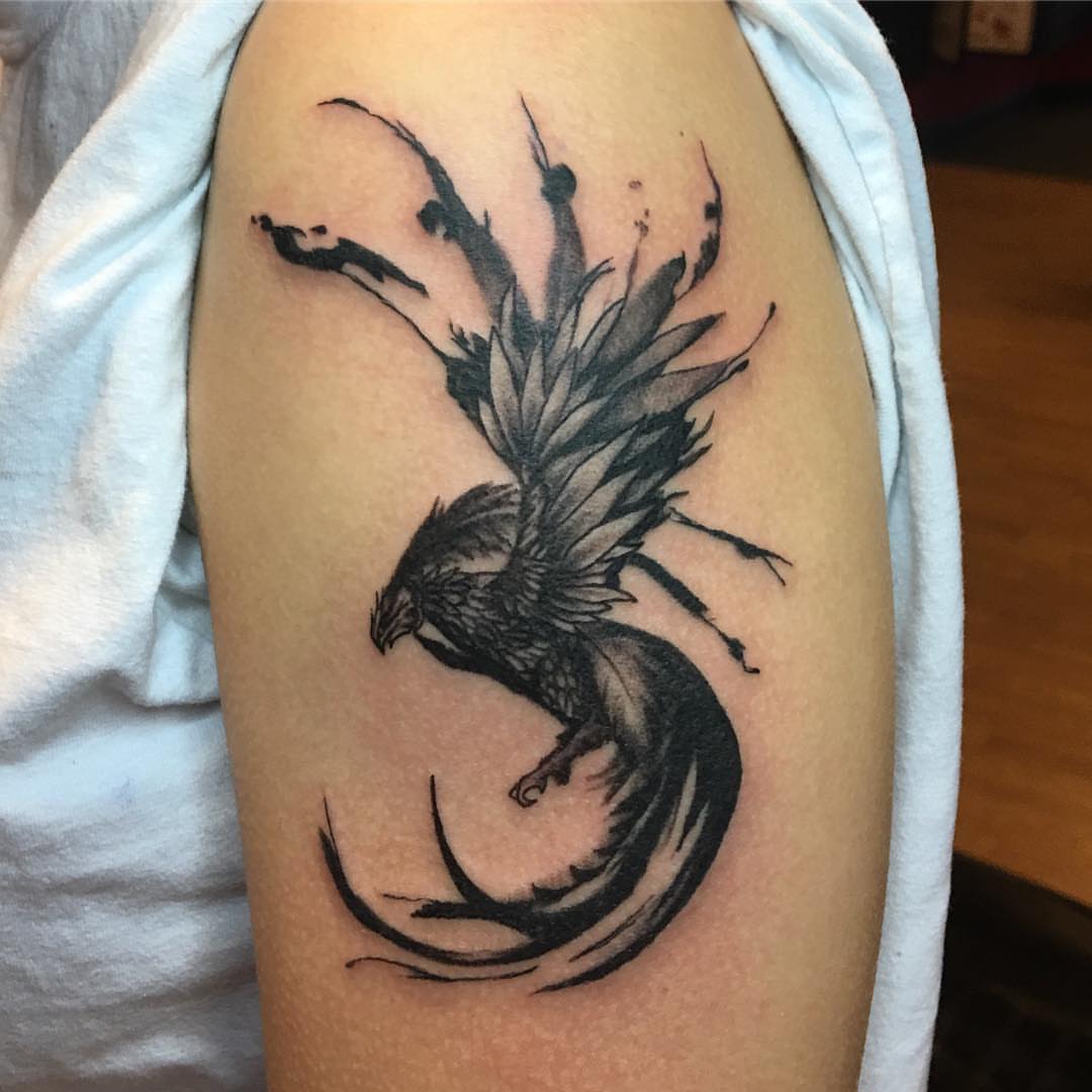 Phoenix black and grey tattoo on the upper arm by Zac Presley
