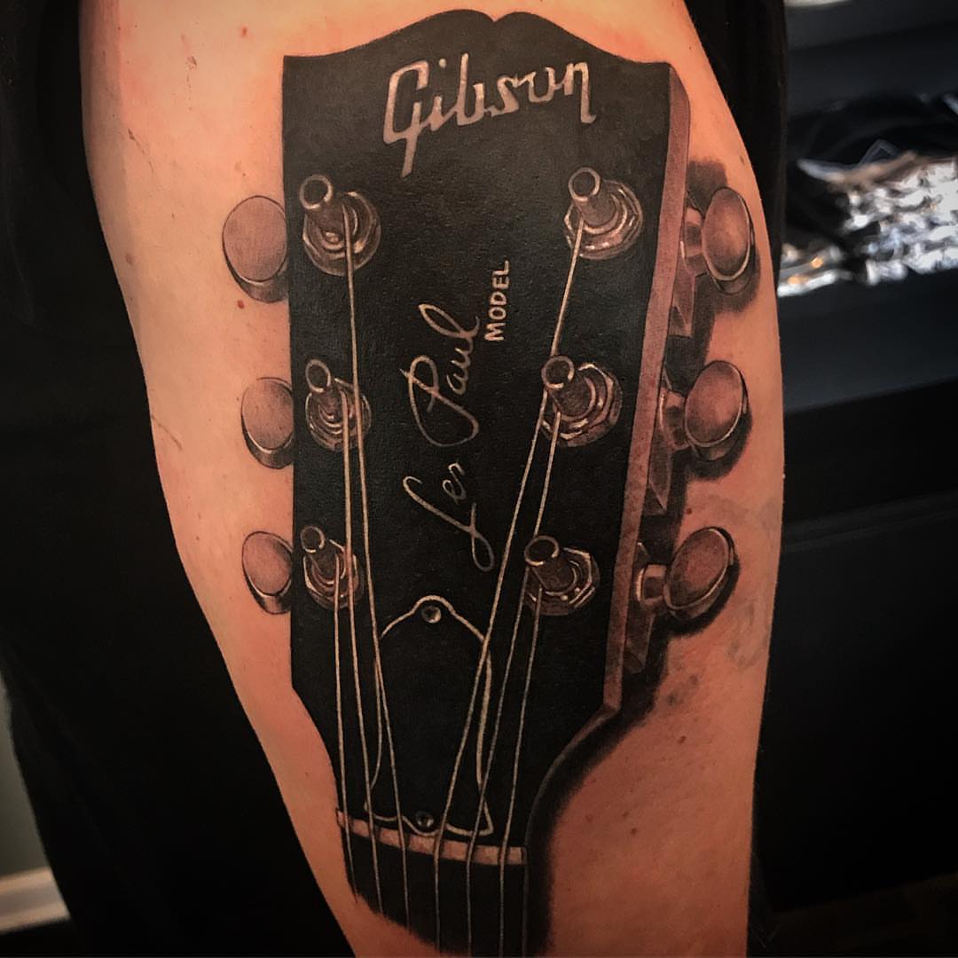 Guitar headstock realism tattoo on the forearm by Jared Ammons