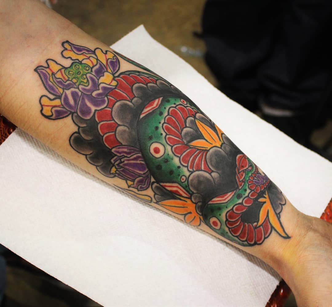 Koi fish and lotus American traditional tattoo on the forearm by Rue McLean