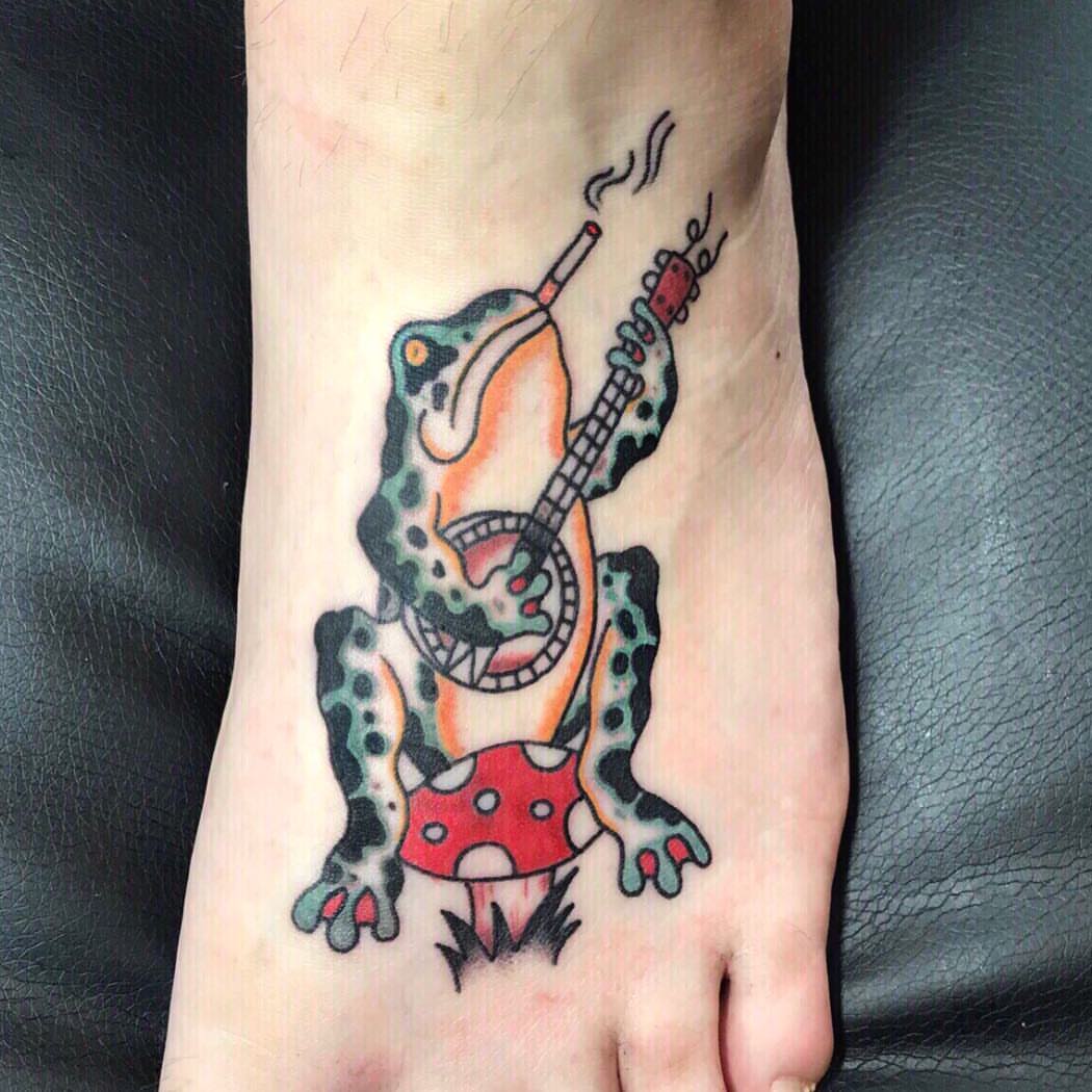 Frog playing guitar American traditional tattoo on the foot by Danielle Dubois