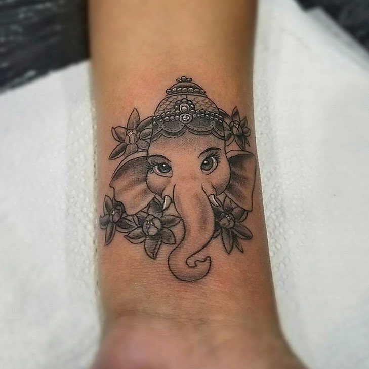 Elephant with floral crown black and grey tattoo on the forearm by Felix 🔸 Chesto (Tattooers)
