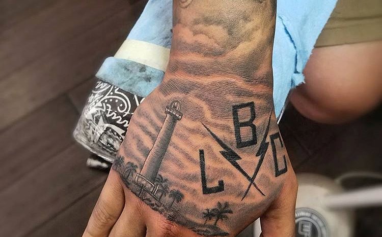 Lighthouse and palm trees black and grey tattoo on the hand by Felix 🔸 Chesto (Tattooers)