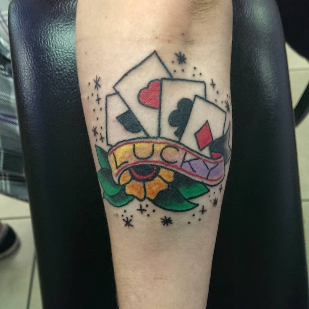 Cards and flower American traditional tattoo on the forearm by Rue McLean