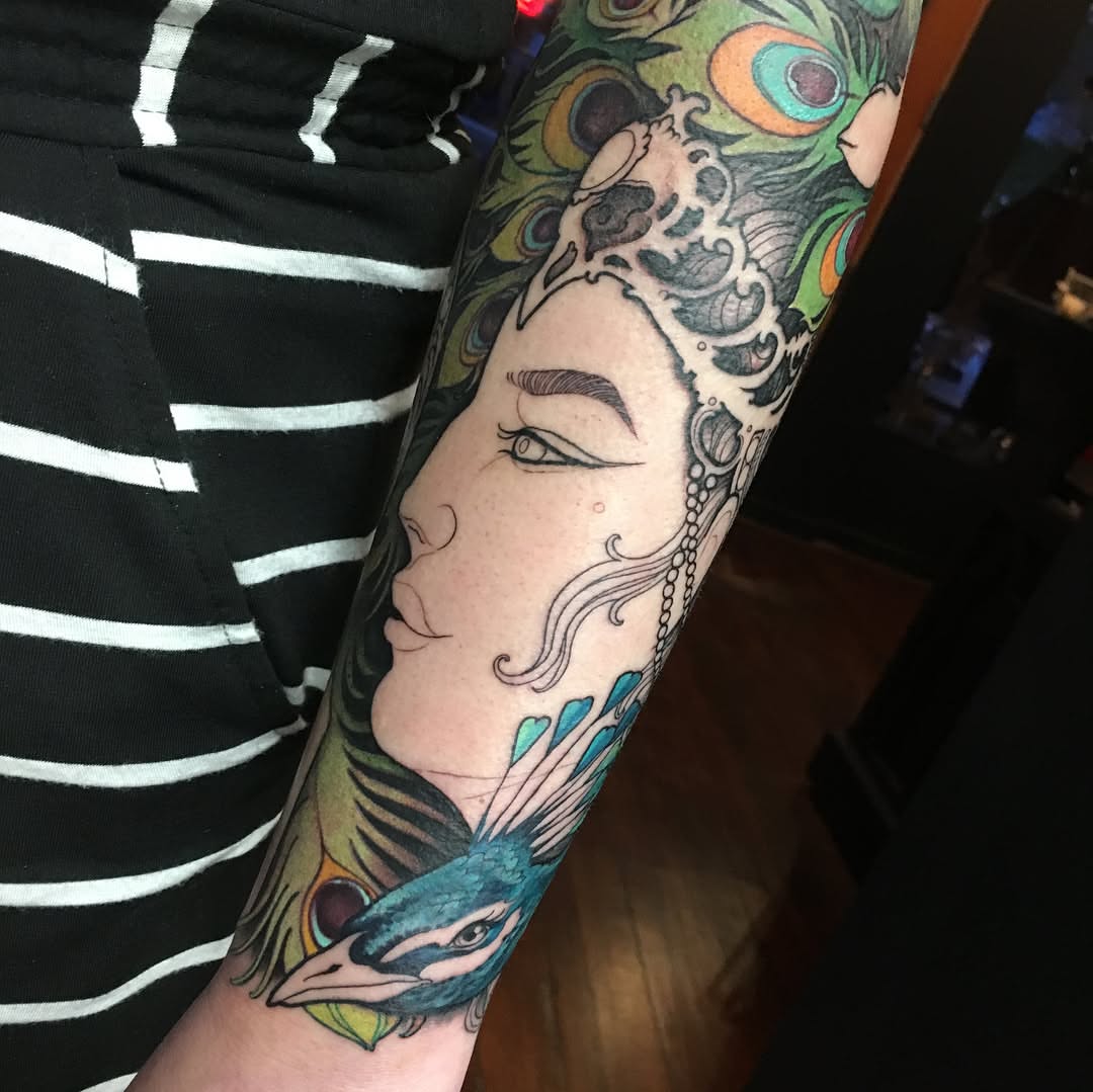 Peacock and woman neo-traditional tattoo on the forearm by Erin Chance