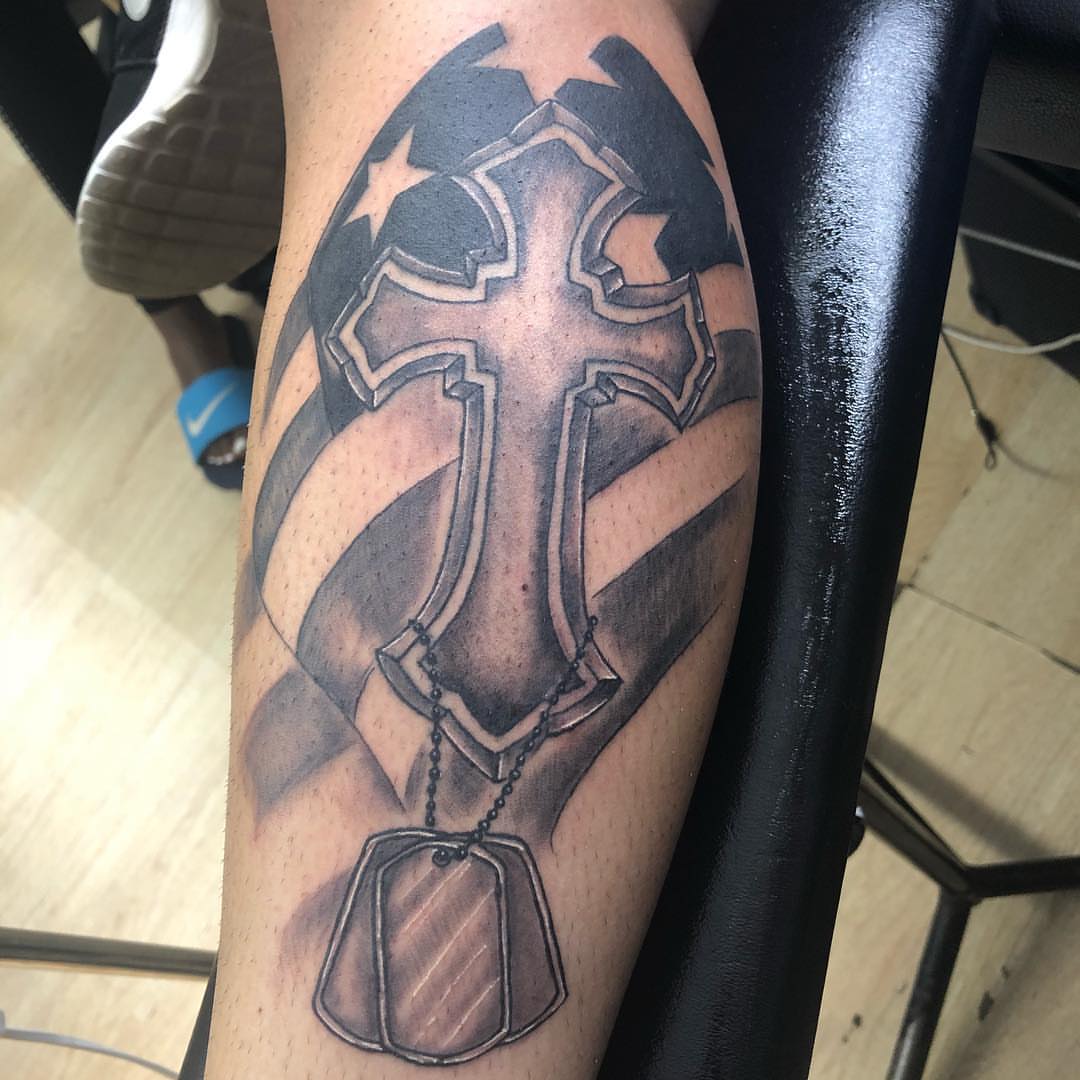 Cross with dog tags black and grey tattoo on the forearm by pecous