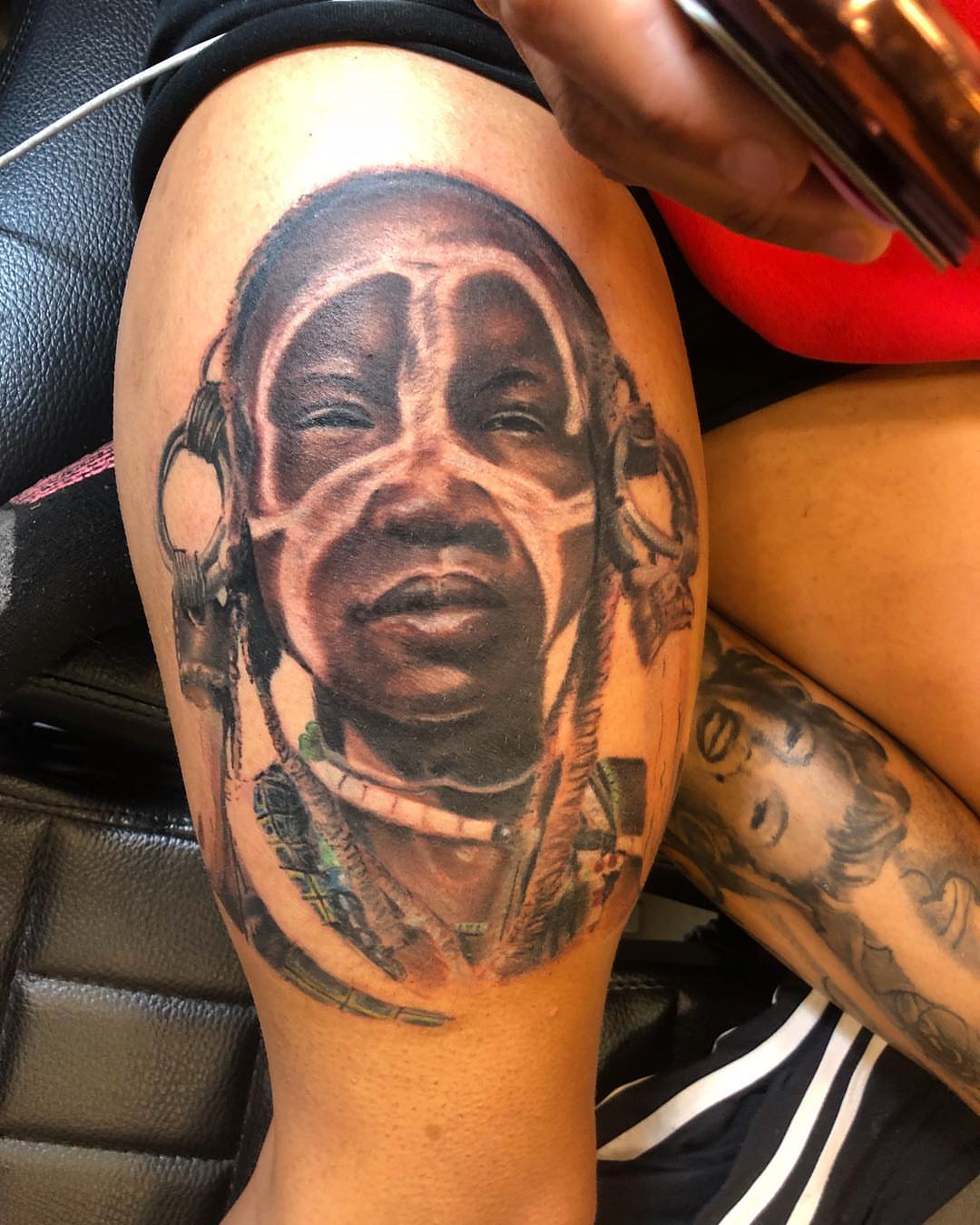 Portrait realism tattoo on the thigh by Sly Davis