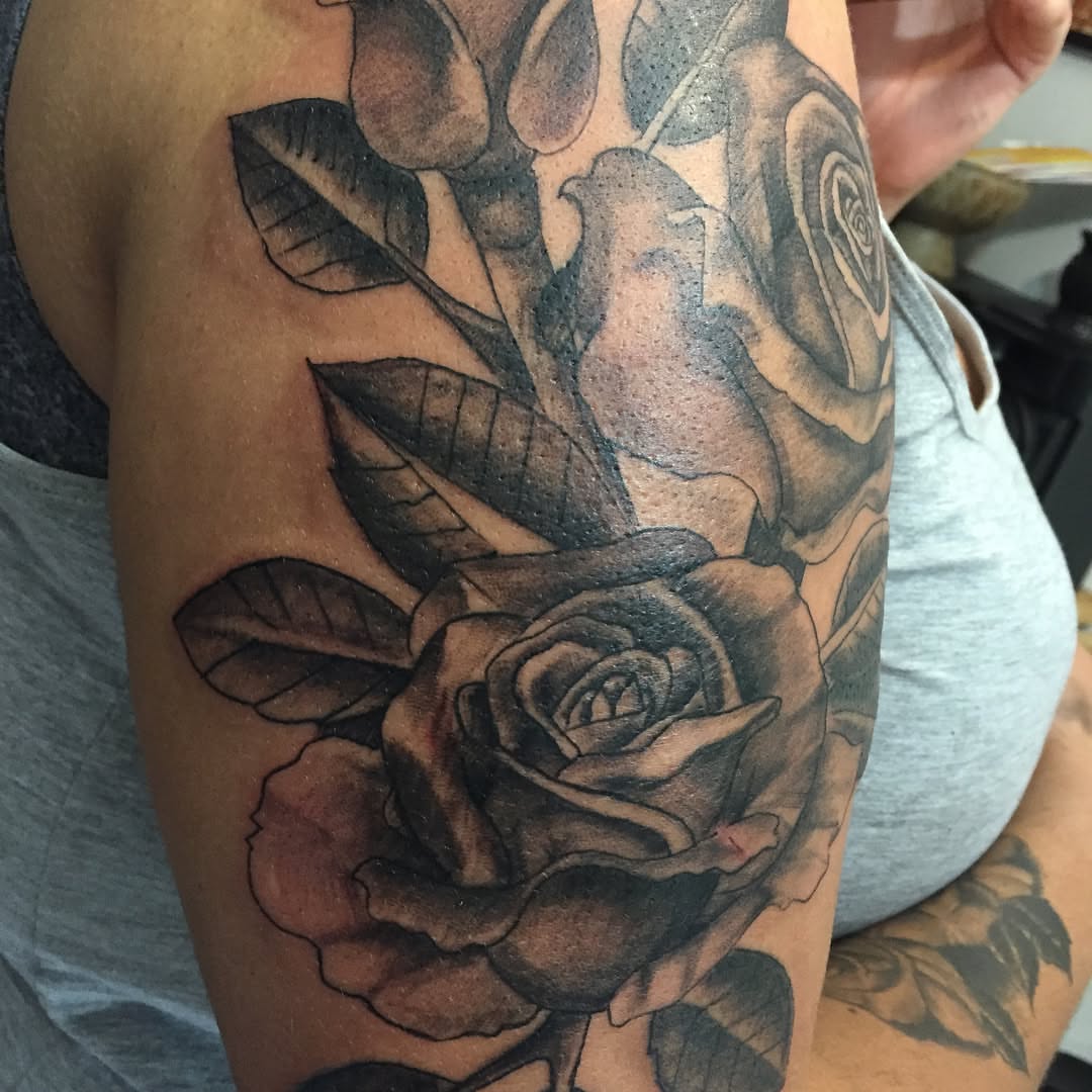 Rose realism tattoo on the upper arm by Junior Trevino