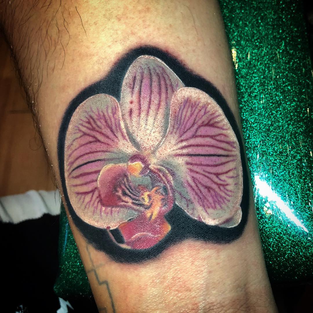 Orchid realism tattoo on the forearm by alexandra