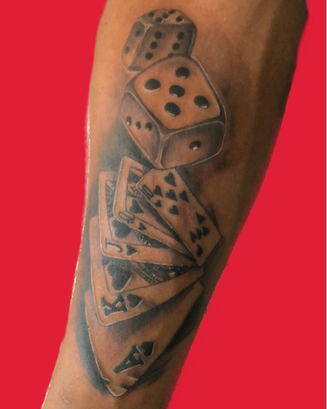 Playing cards and dice black and grey tattoo on the forearm by pecous