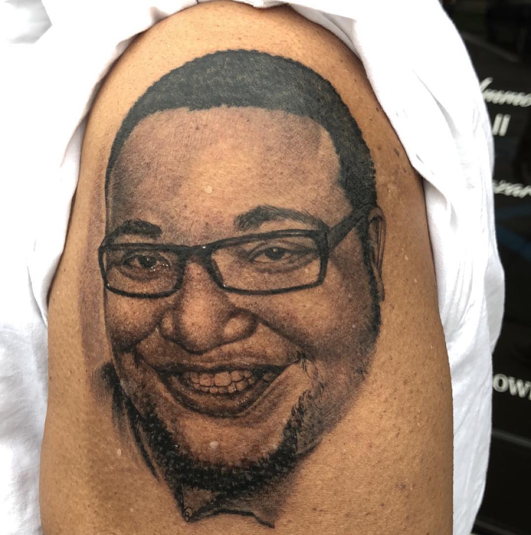 Portrait realism tattoo on the upper arm by Jared Ammons