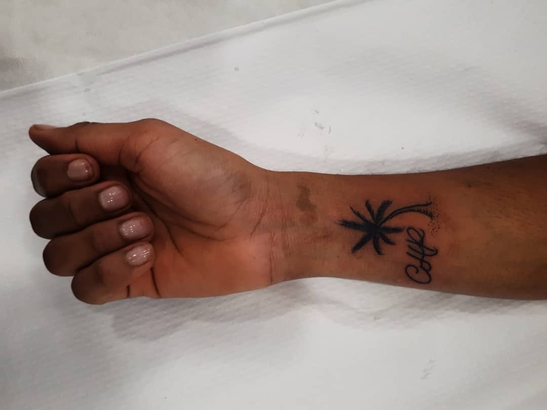 Palm tree and script lettering tattoo on the forearm by 212tattoomalaga, Málaga, Spain