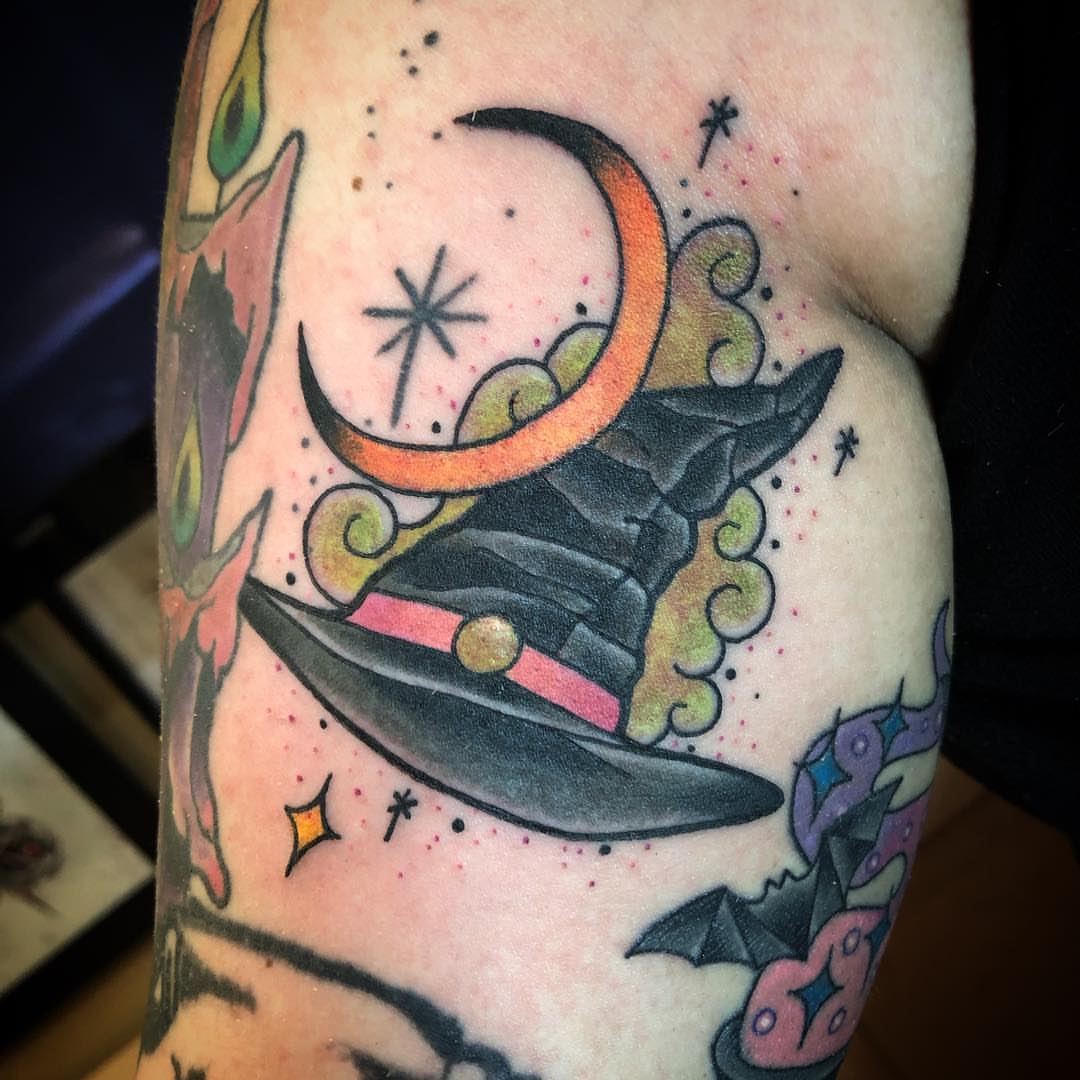 Witch hat and crescent moon American traditional tattoo on the forearm by alexandra