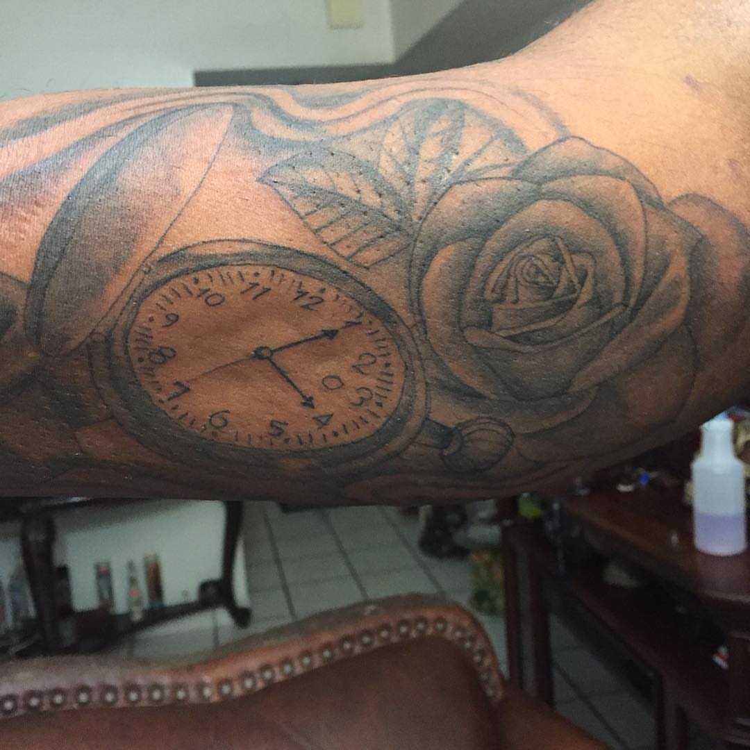 Clock and rose realism tattoo on the forearm by Junior Trevino