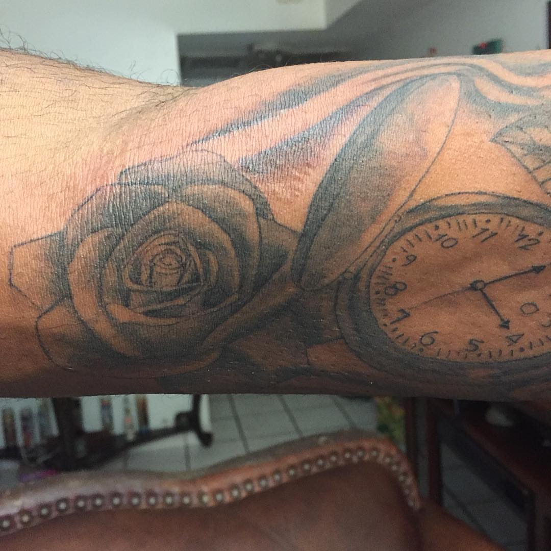 Clock and rose realism tattoo on the forearm by Junior Trevino