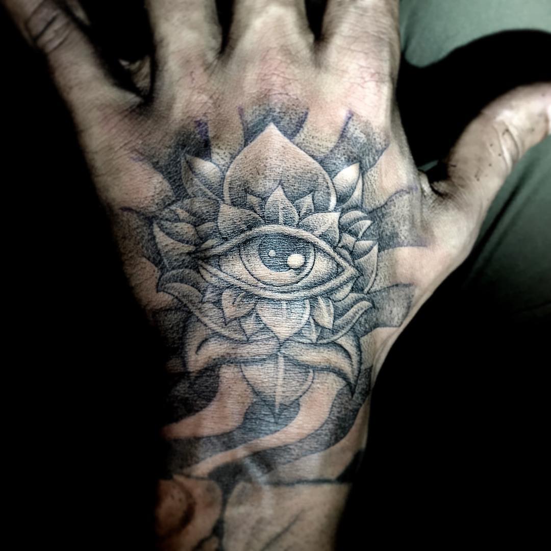 Eye and lotus black and grey tattoo on the hand by Luis Marrufo