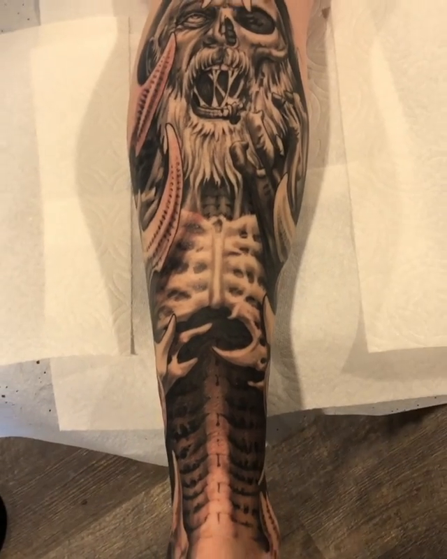 Biomechanical skull and spine dark realism tattoo by Oak Adams