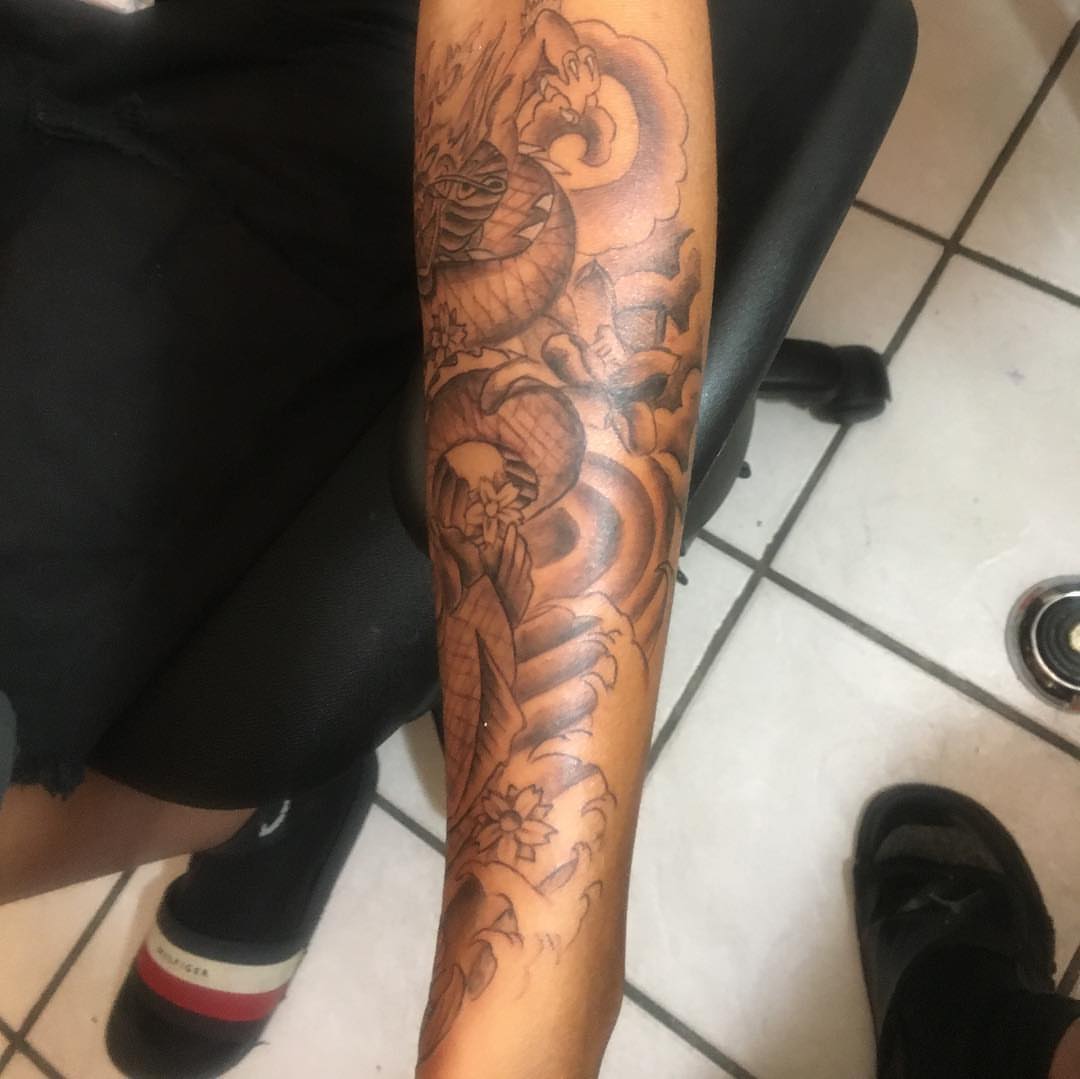 Serpent and flowers japanese irezumi tattoo on the forearm by Junior Trevino
