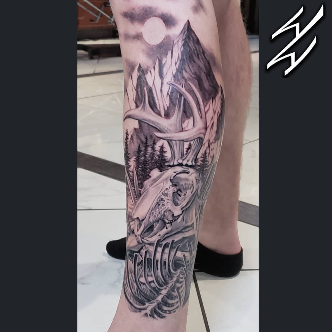 Deer skull and mountain landscape realism tattoo on the calf by Walt Watts, Salt Lake City, Utah