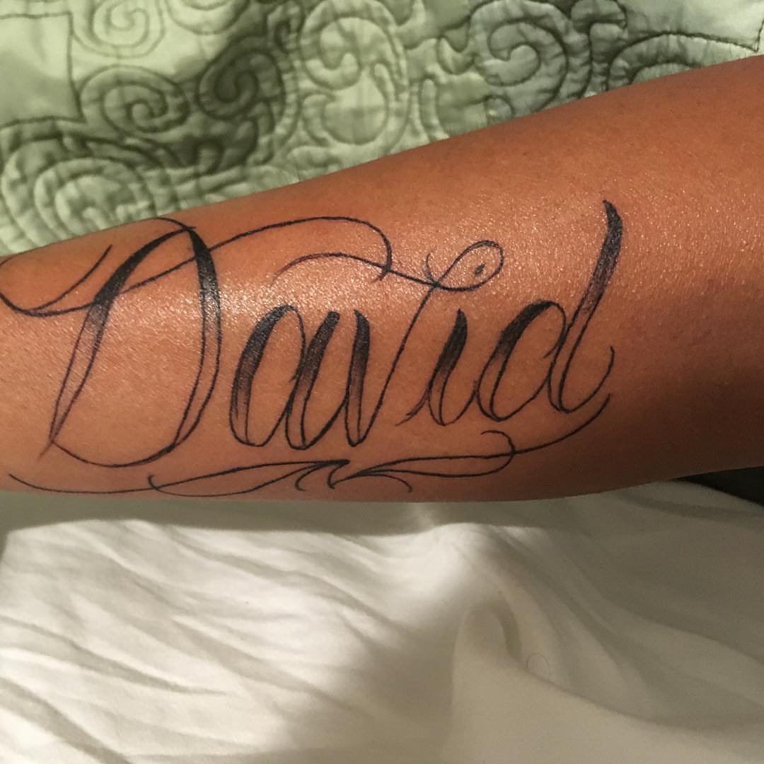 David lettering script tattoo on the forearm by Junior Trevino