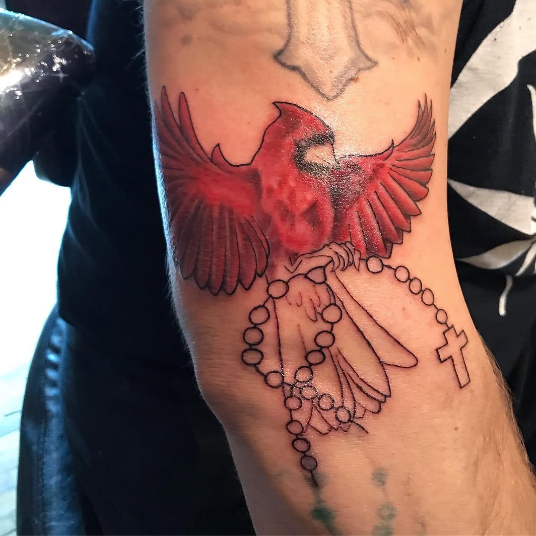 Cardinal holding rosary beads realism tattoo on the forearm by Chris