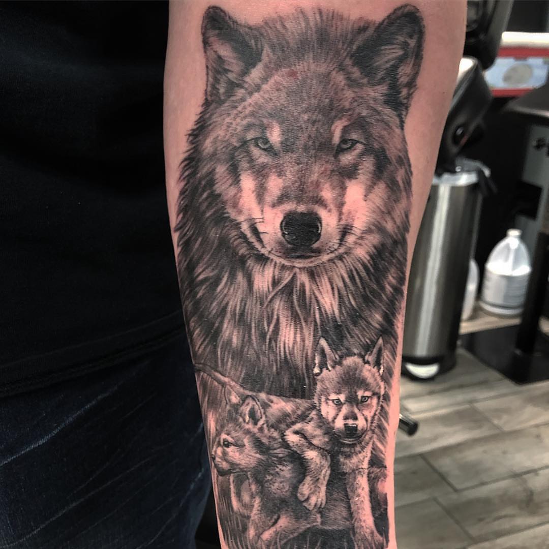 Wolf family realism tattoo on the forearm by Jared Ammons
