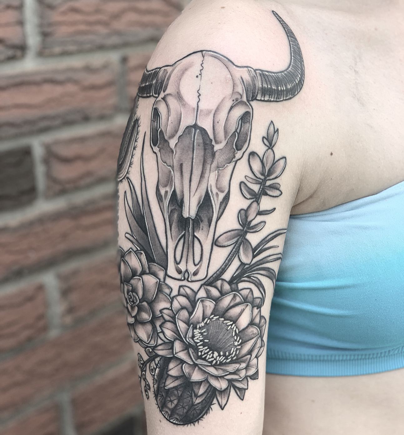 Bull skull and flowers realism tattoo on the forearm by Shelby Ouellette