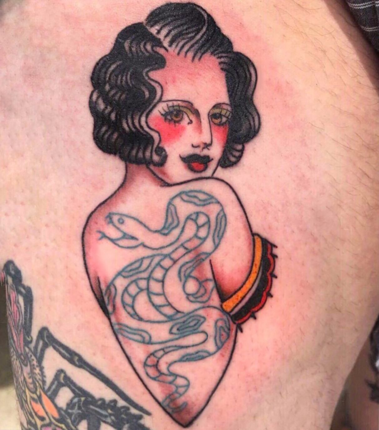 Woman with snake American traditional tattoo on the thigh by Danielle Dubois
