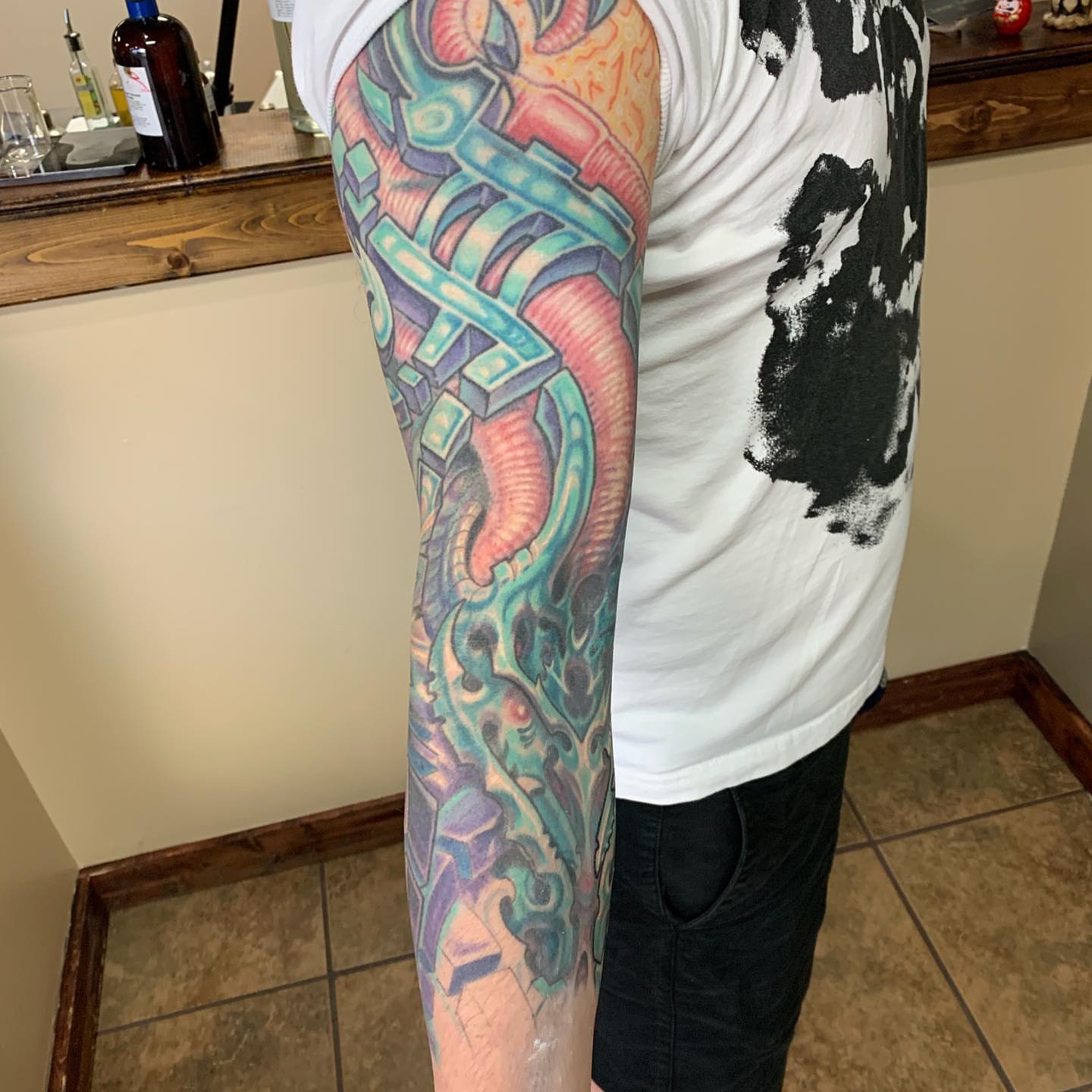 Mechanical arm geometric tattoo on the forearm by Phil Robertson