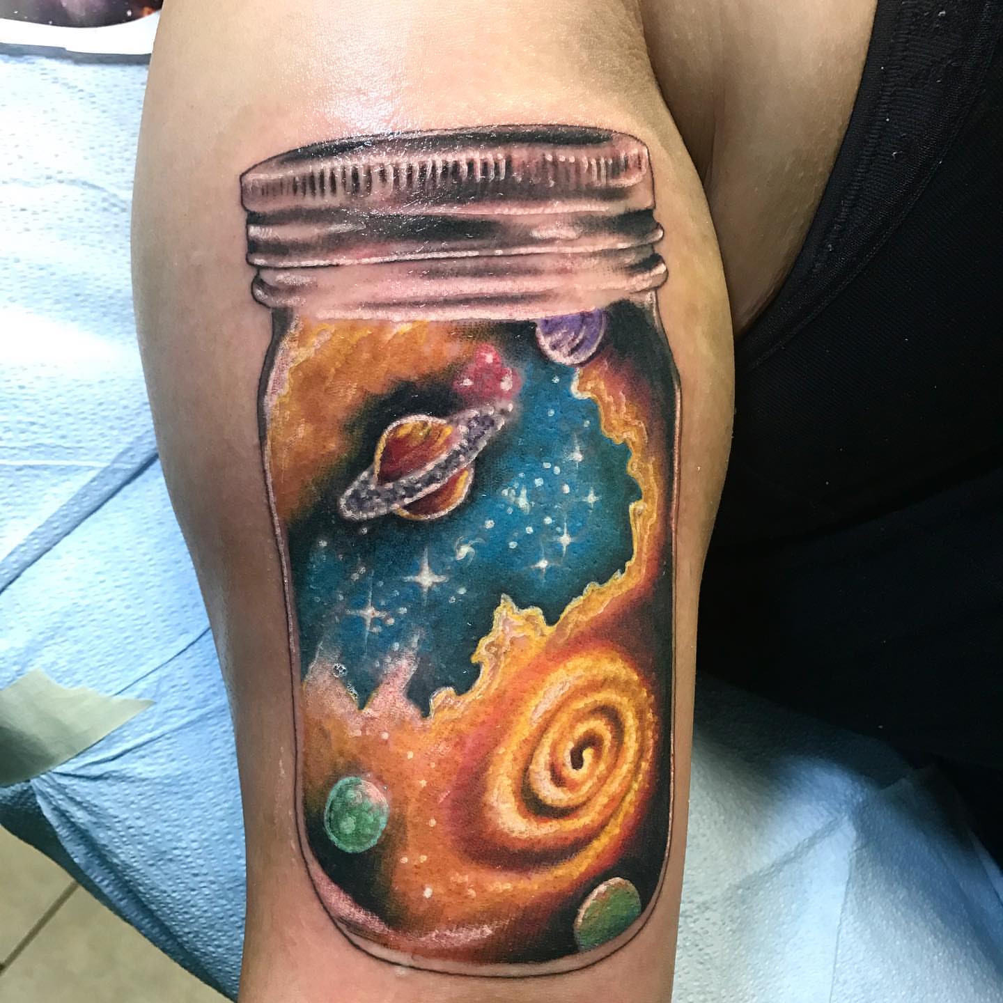 Space in a jar realism tattoo on the forearm by Trevor Sibary