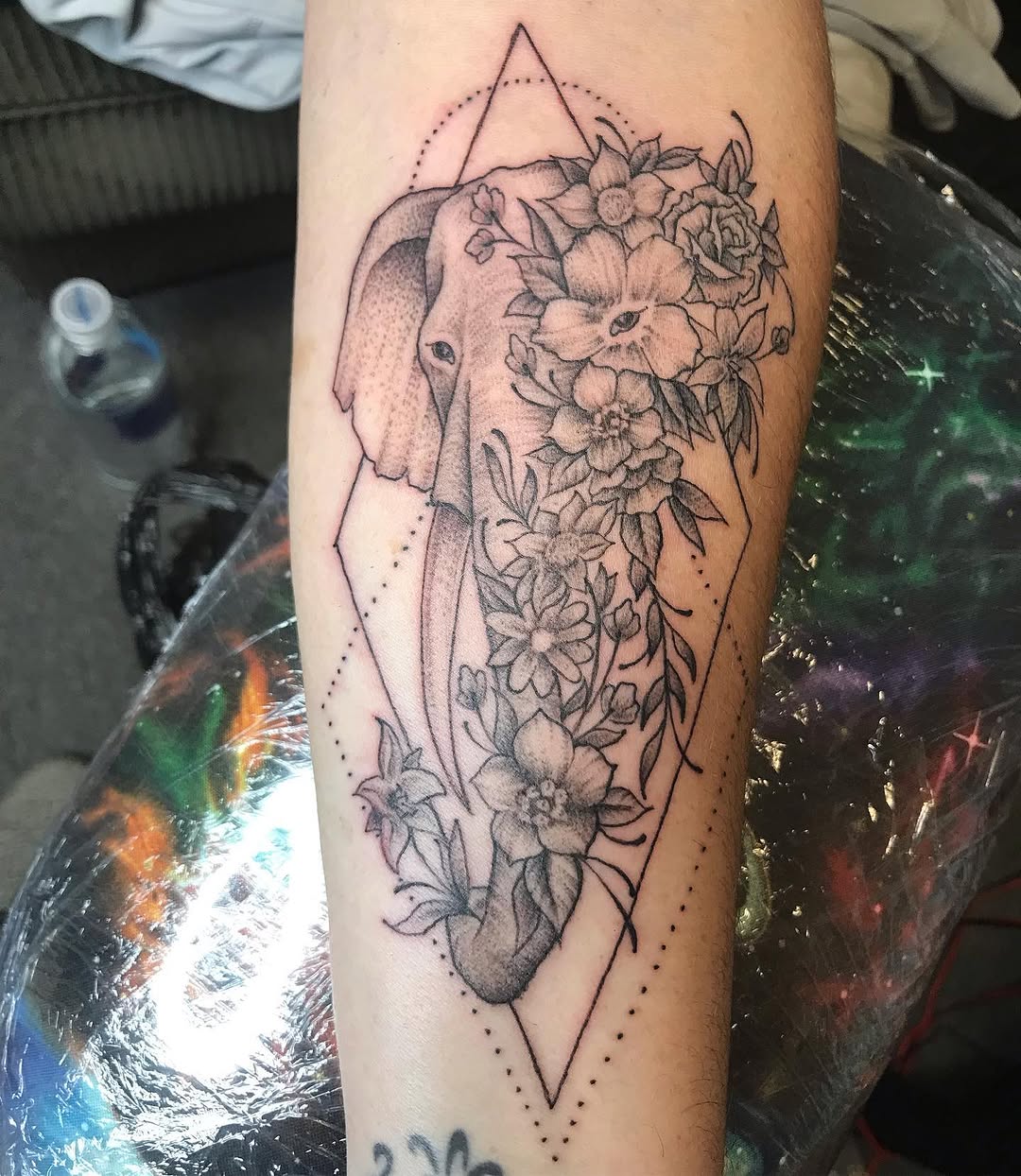 Elephant head with flowers dotwork tattoo on the forearm by Chris