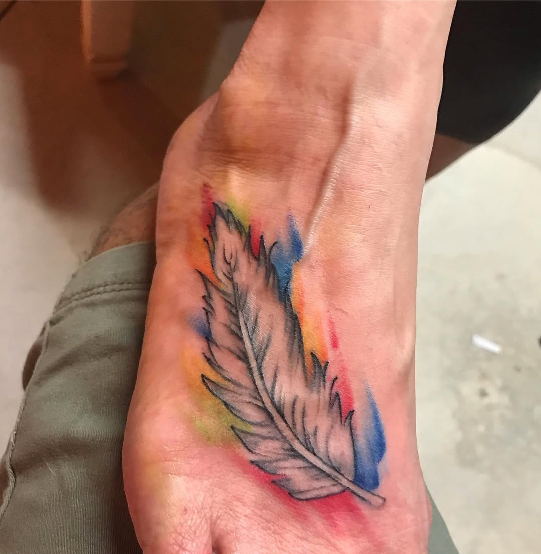 Feather watercolor tattoo on the foot by Chris