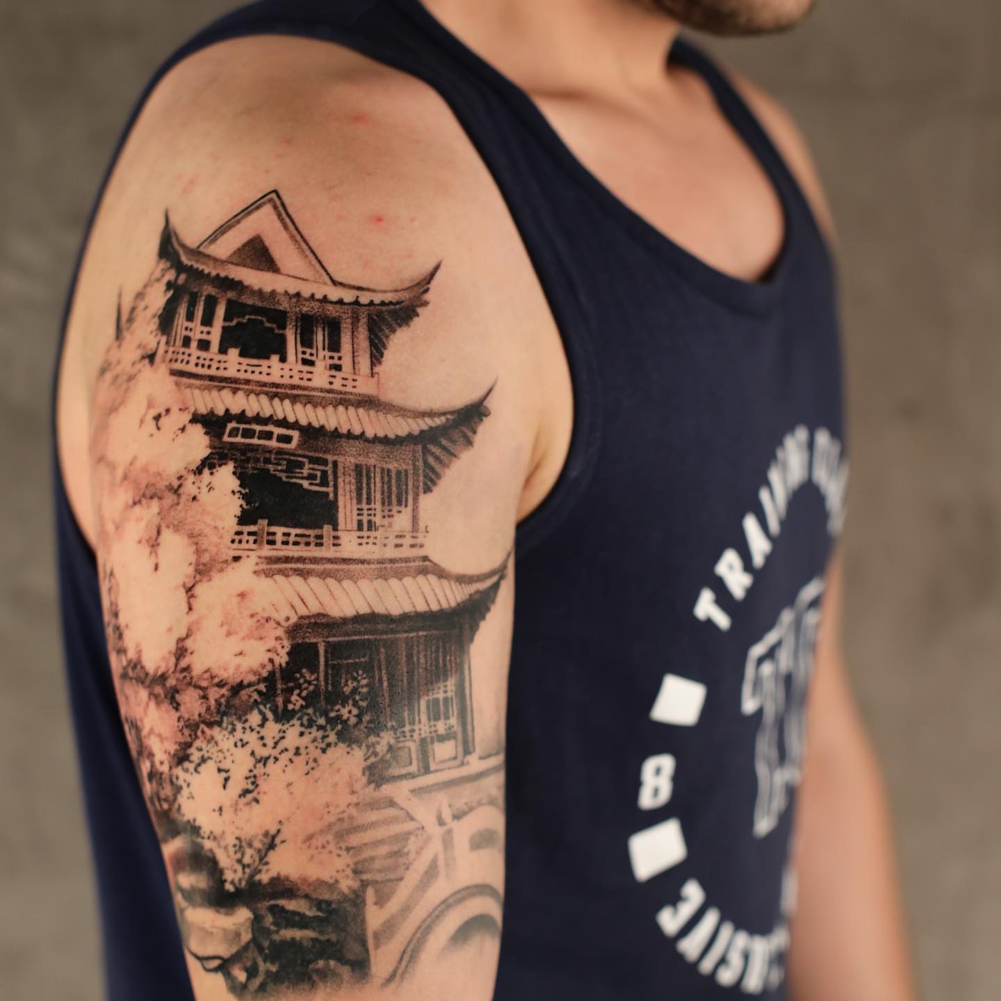 Chinese pagoda black and grey tattoo on the upper arm by Anna Chernova, San Francisco, California