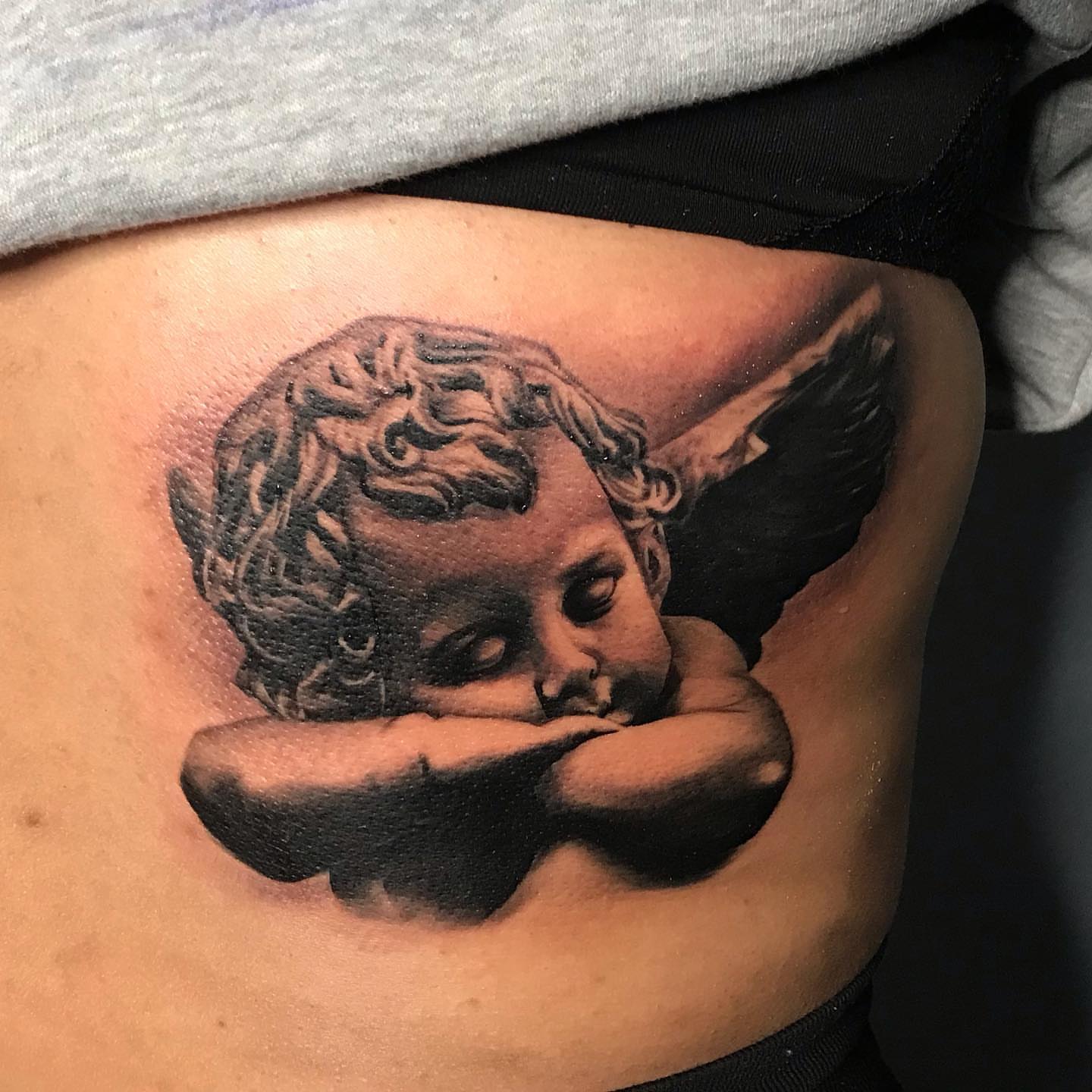 Cherub realism tattoo on the ribs by Jayjay🦅