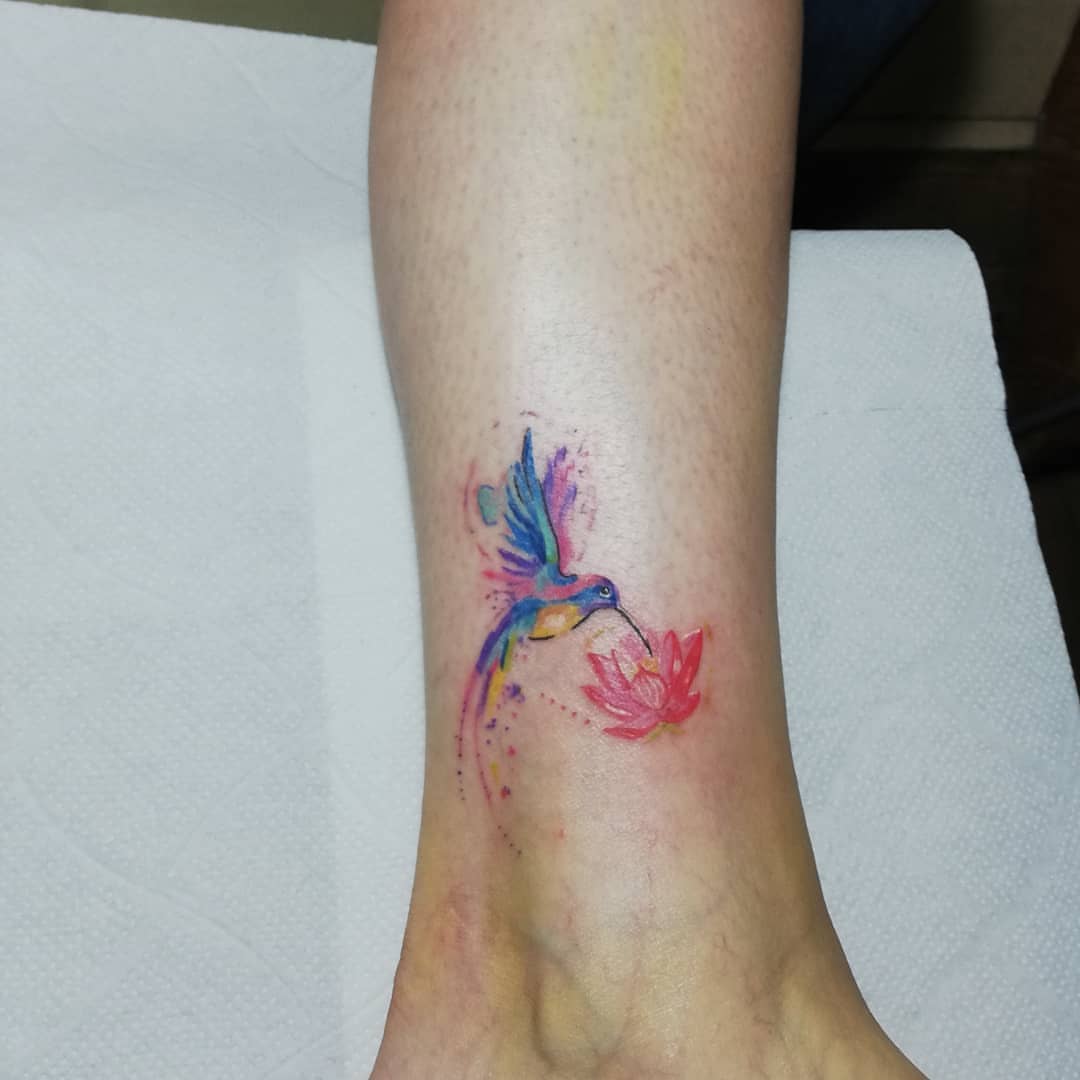 Hummingbird and lotus watercolor tattoo on the calf by Diego Aravena