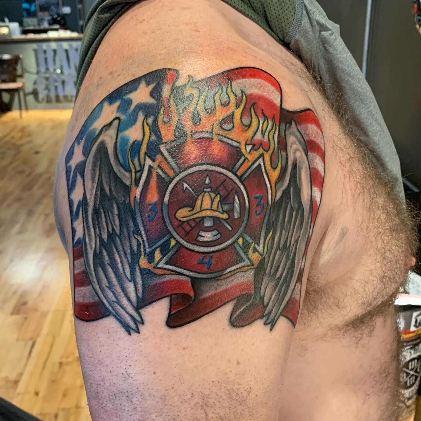 Firefighter badge American traditional tattoo on the shoulder by Jeff Kees