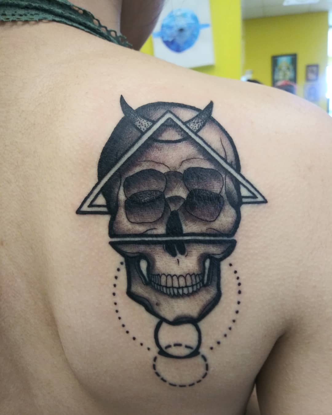 Skull with triangle black and grey tattoo on the shoulder by Herc
