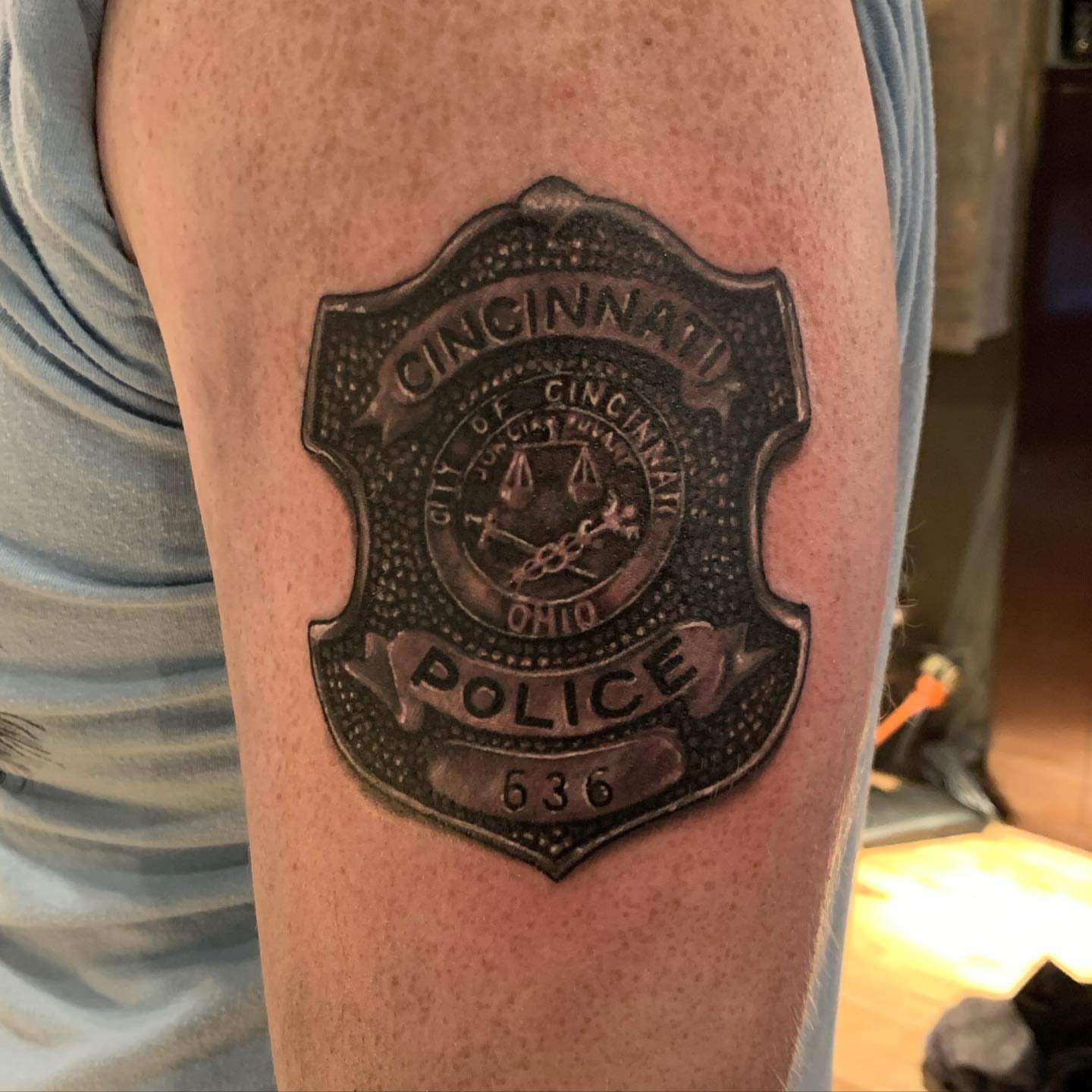 Cincinnati Police badge black and grey tattoo on the forearm by Jeff Kees
