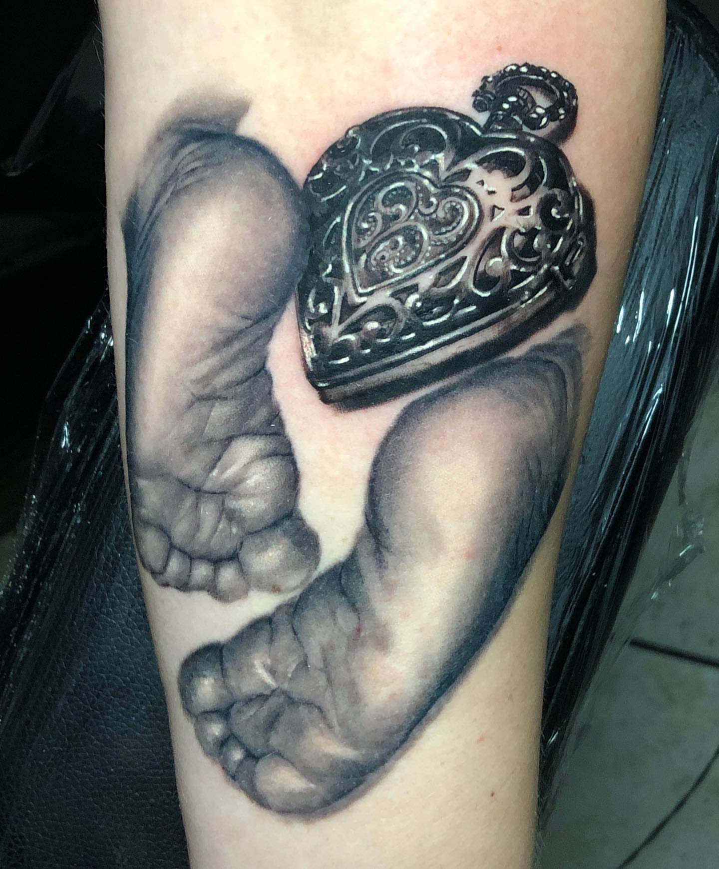 Baby feet and pocket watch realism tattoo on the forearm by Mike Shultz