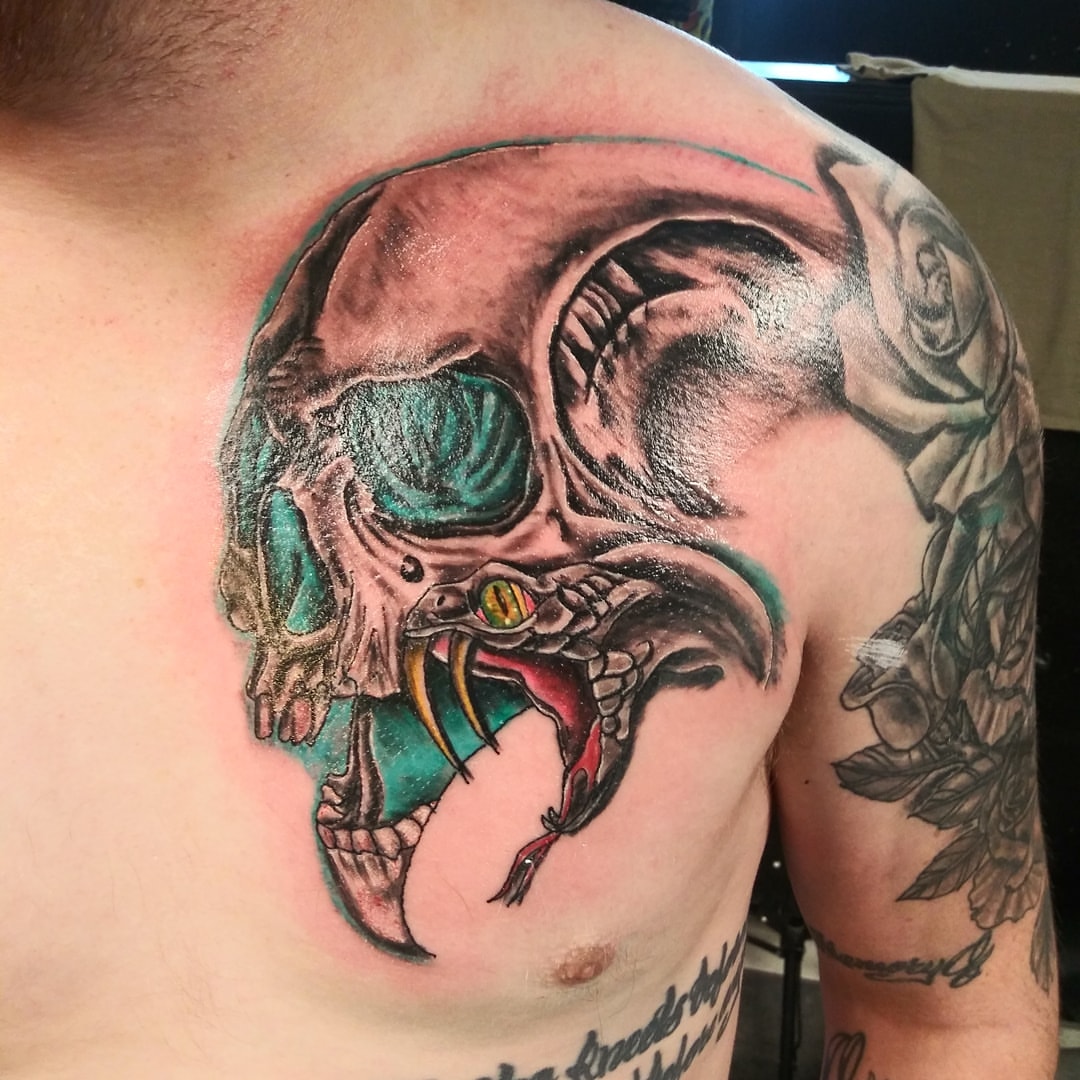 Skull with snake dark realism tattoo on the shoulder by Glen Wallis