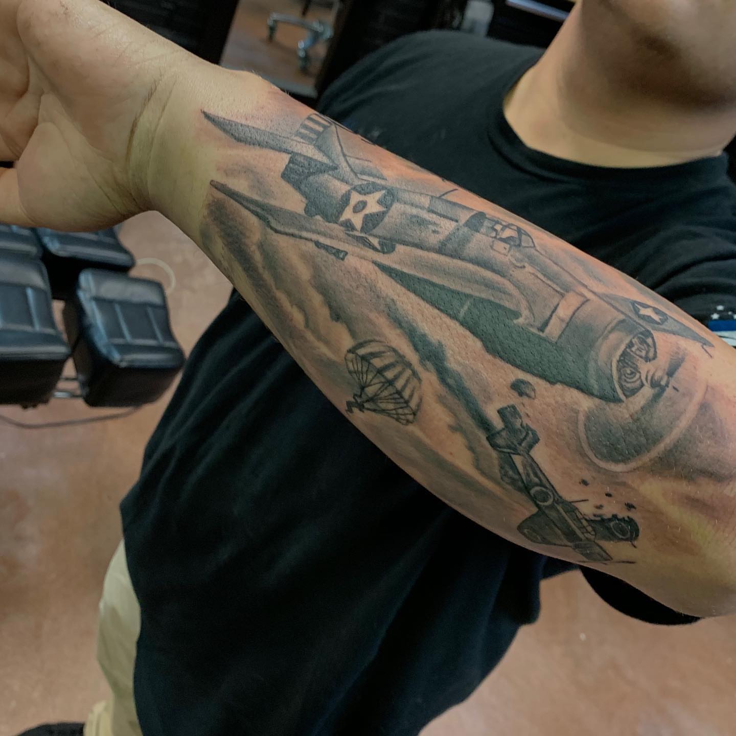 Military aircraft and parachute black and grey tattoo on the forearm by Mikeyftsk2