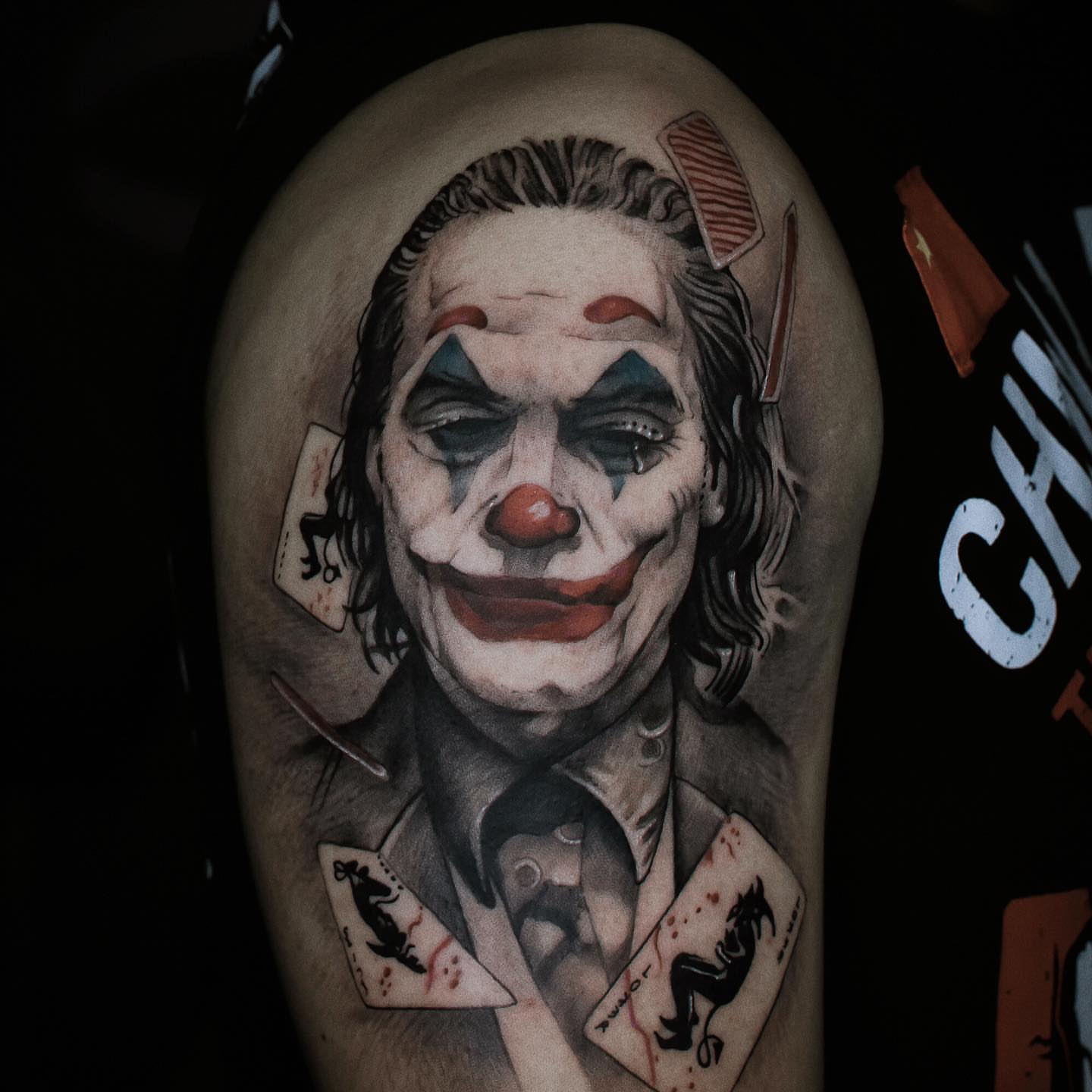 Joker realism tattoo on the upper arm by Duo