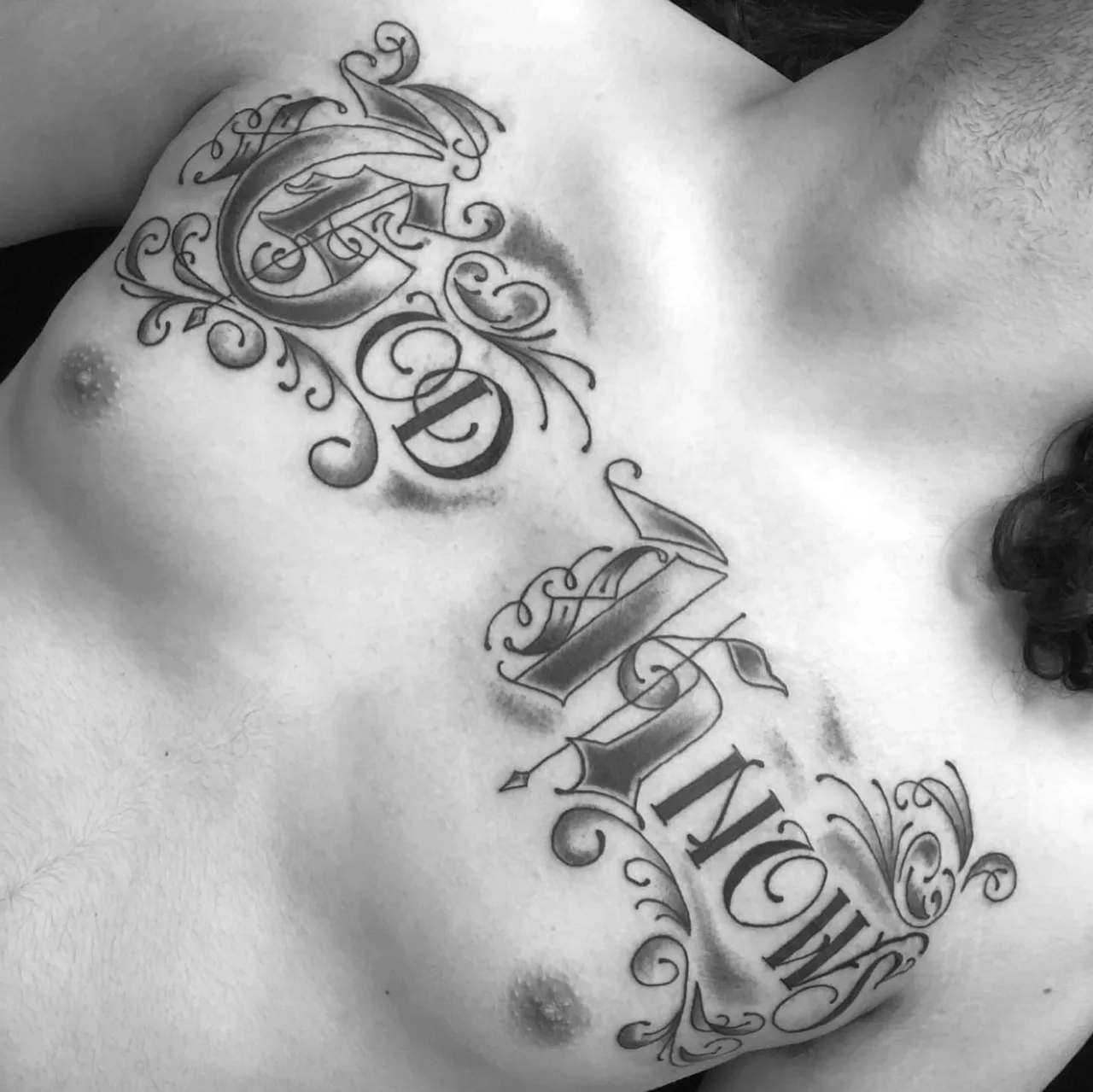 GD NOW lettering script tattoo on the chest by Charlie Soto