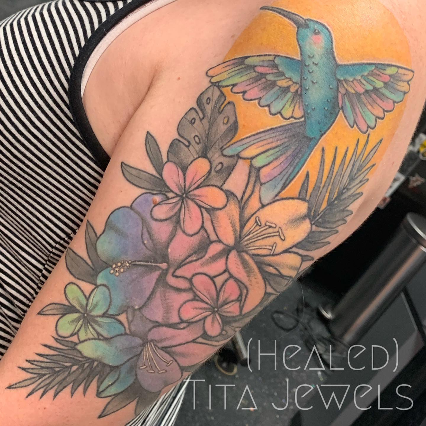 Hummingbird and tropical flowers new school tattoo on the upper arm by Tita Jewels- Tattoo Artist, Austin, Texas