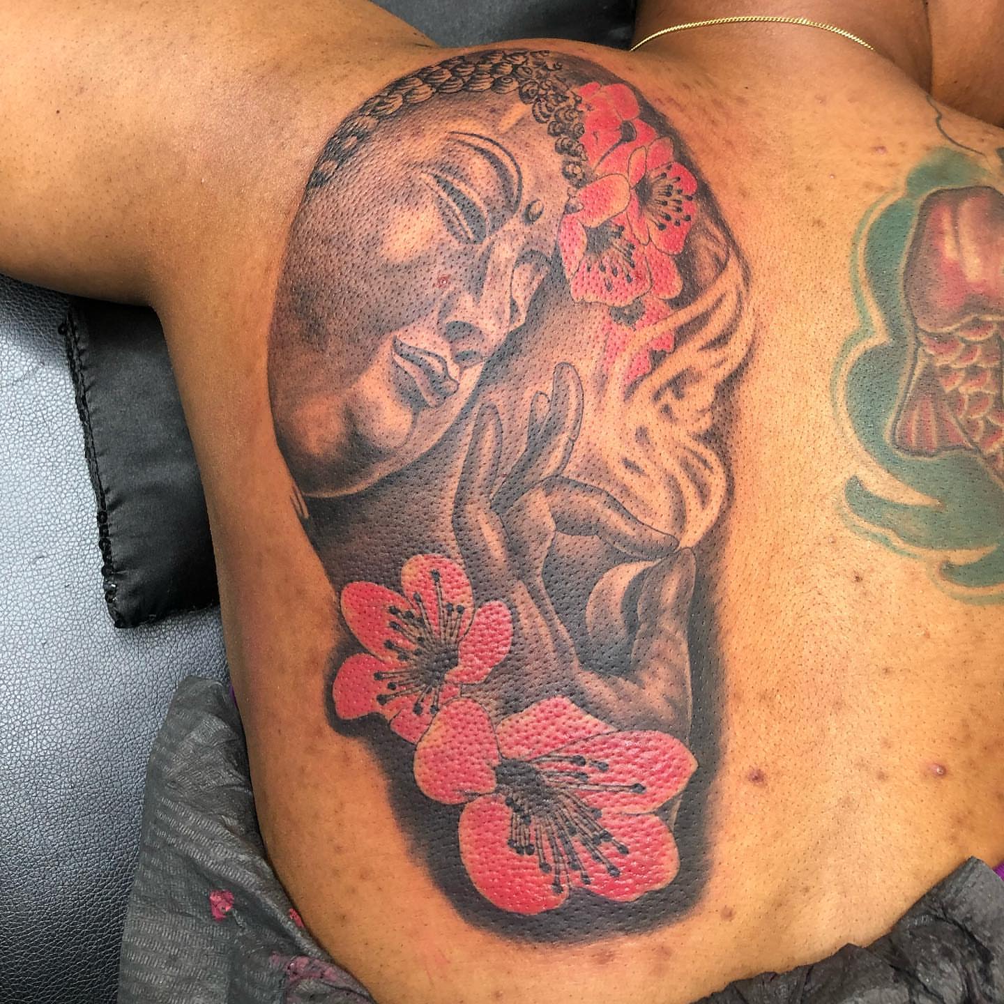 Buddha with flowers dotwork tattoo on the shoulder by pecous